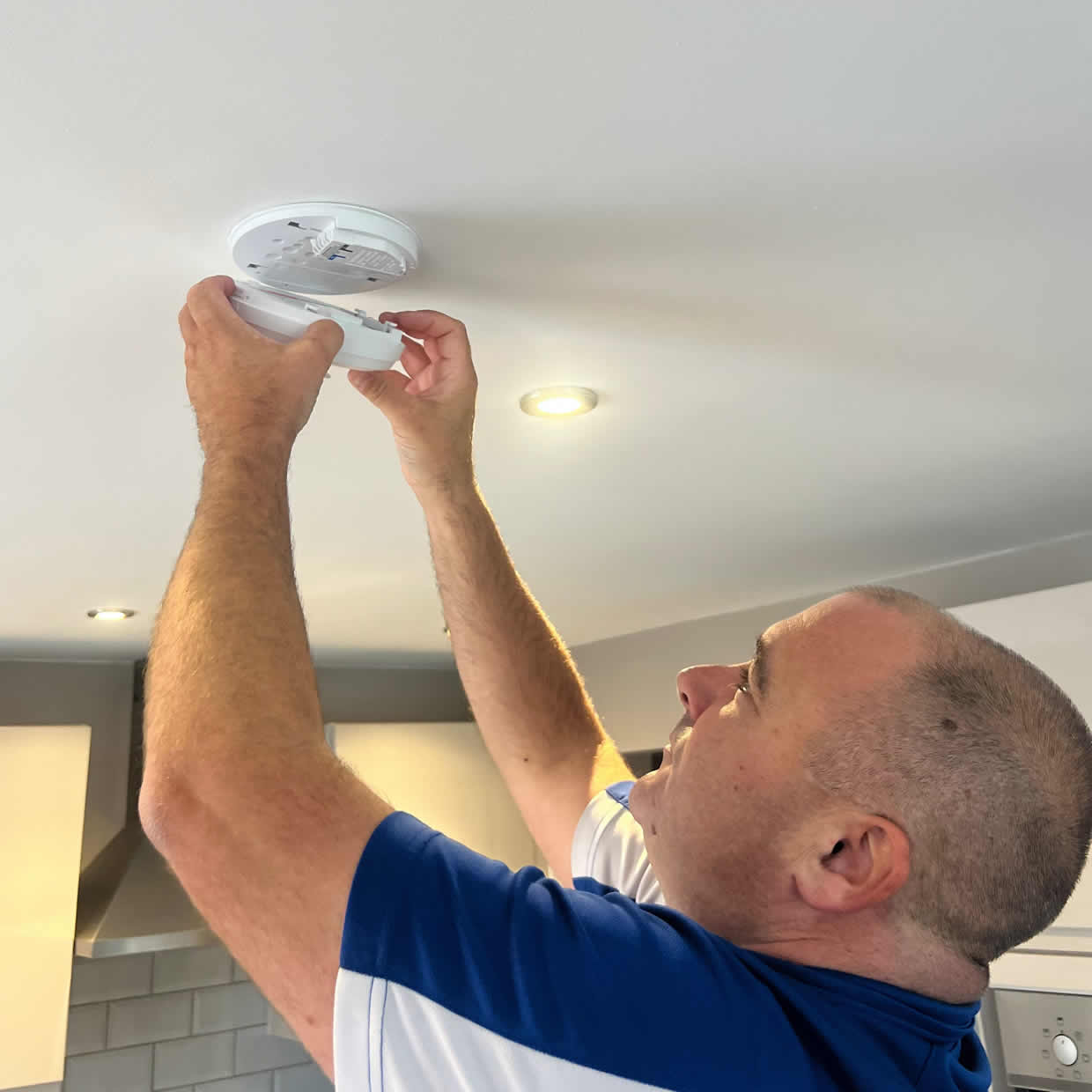 Smoke alarm installer fitting an alarm in an Aberdeen property